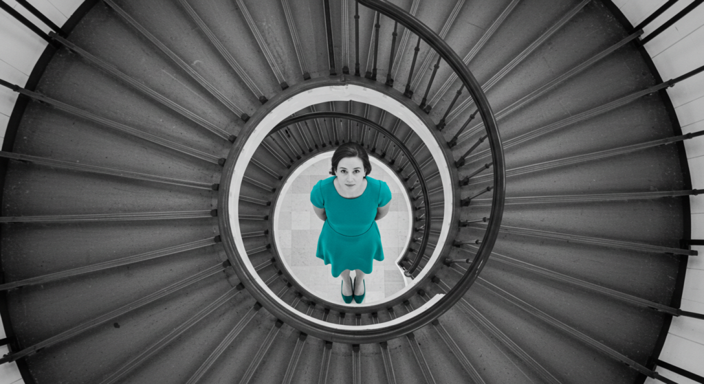 a photo of a woman at the end of a spiral staircase. how leaders think
